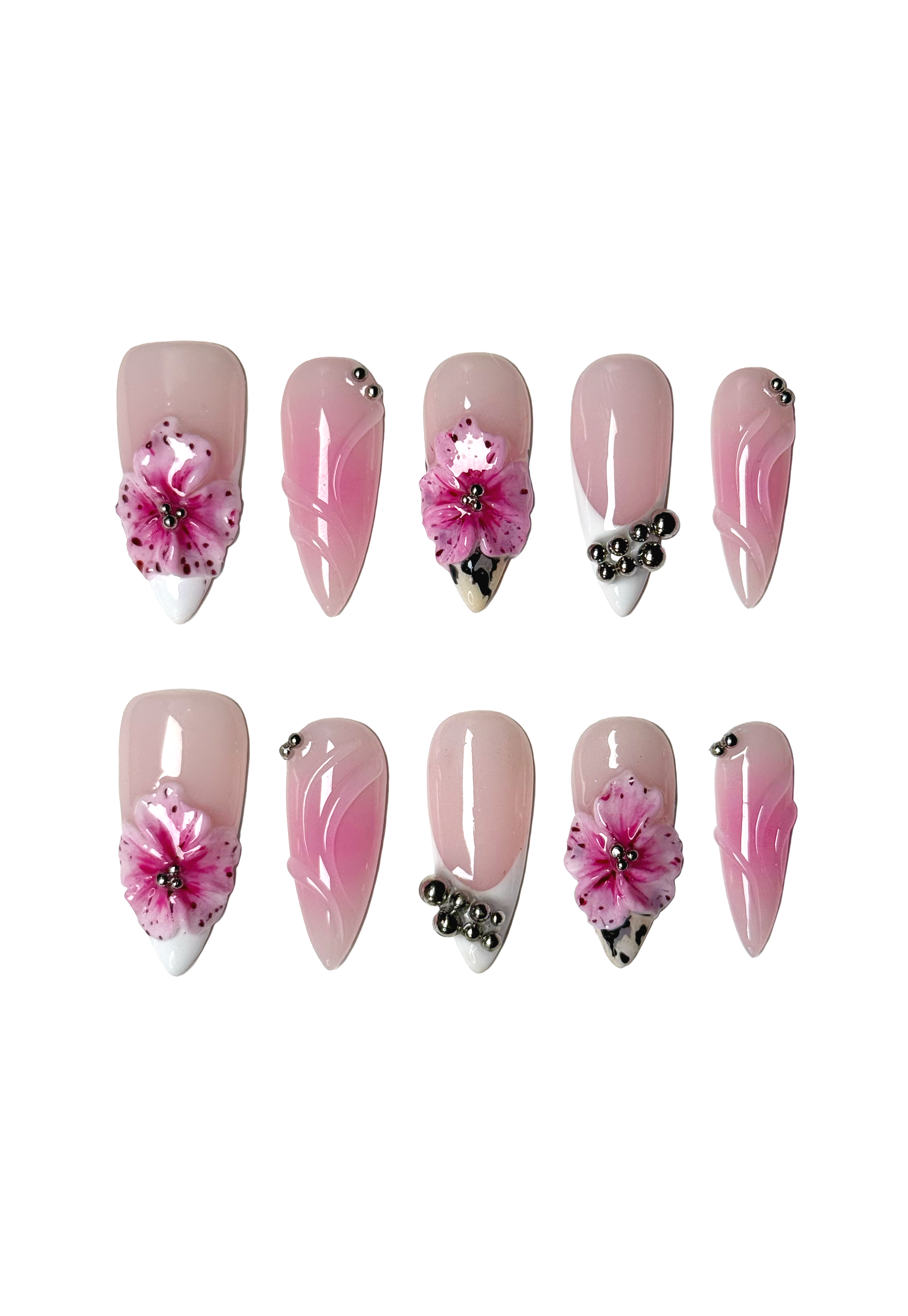 Stiletto press-on nails with pink 3D hibiscus flowers, silver studs, and white French tip accents on a glossy nude base